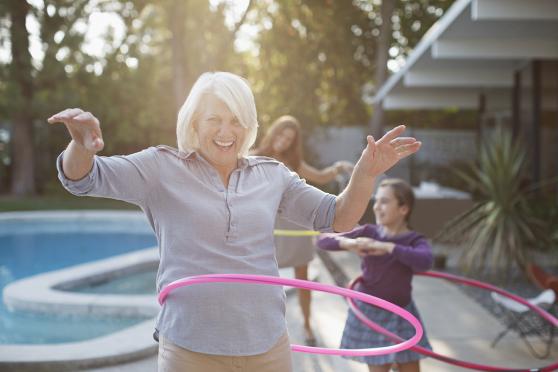 Photo: Woman playing with hula hoop with grandchildren